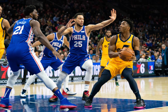Donovan Mitchell (45) looks to shoot over Ben Simmons (25) and Joel Embiid (21)